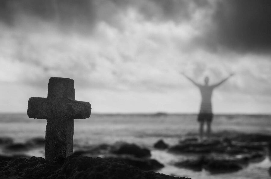 symbolic-crucifix-and-ghosted-man-with-arms-raised-istock_36701070_xlarge-2-e1540283126984