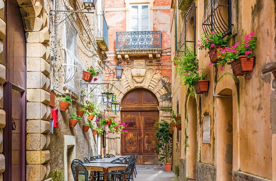 A charming street in Positano, Italy. Tables await diners as tourists settle in for pizza and pasta.