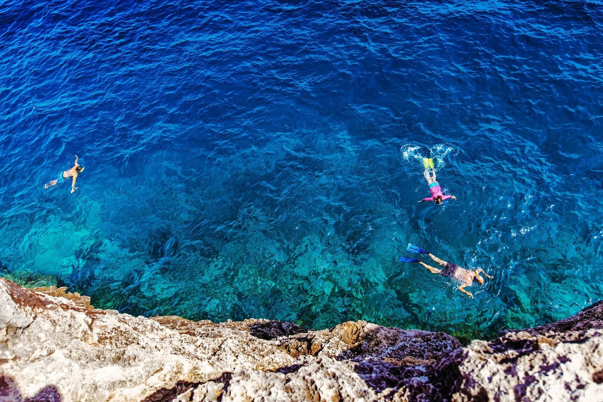 Floating snorkelers in the bay of Cala Pi in Mallorca