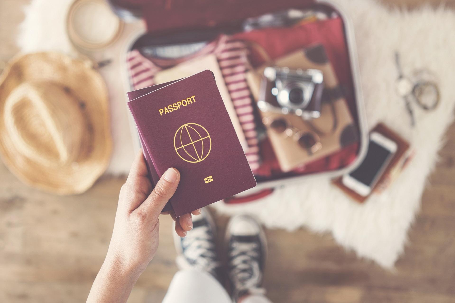 German passport in the foreground, open suitcase in the background