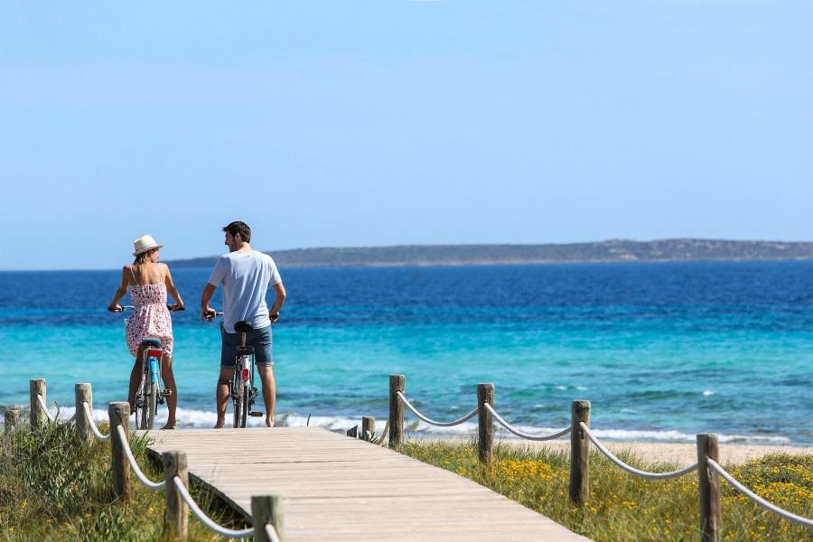 Couple riding bikes on Formentera Island.