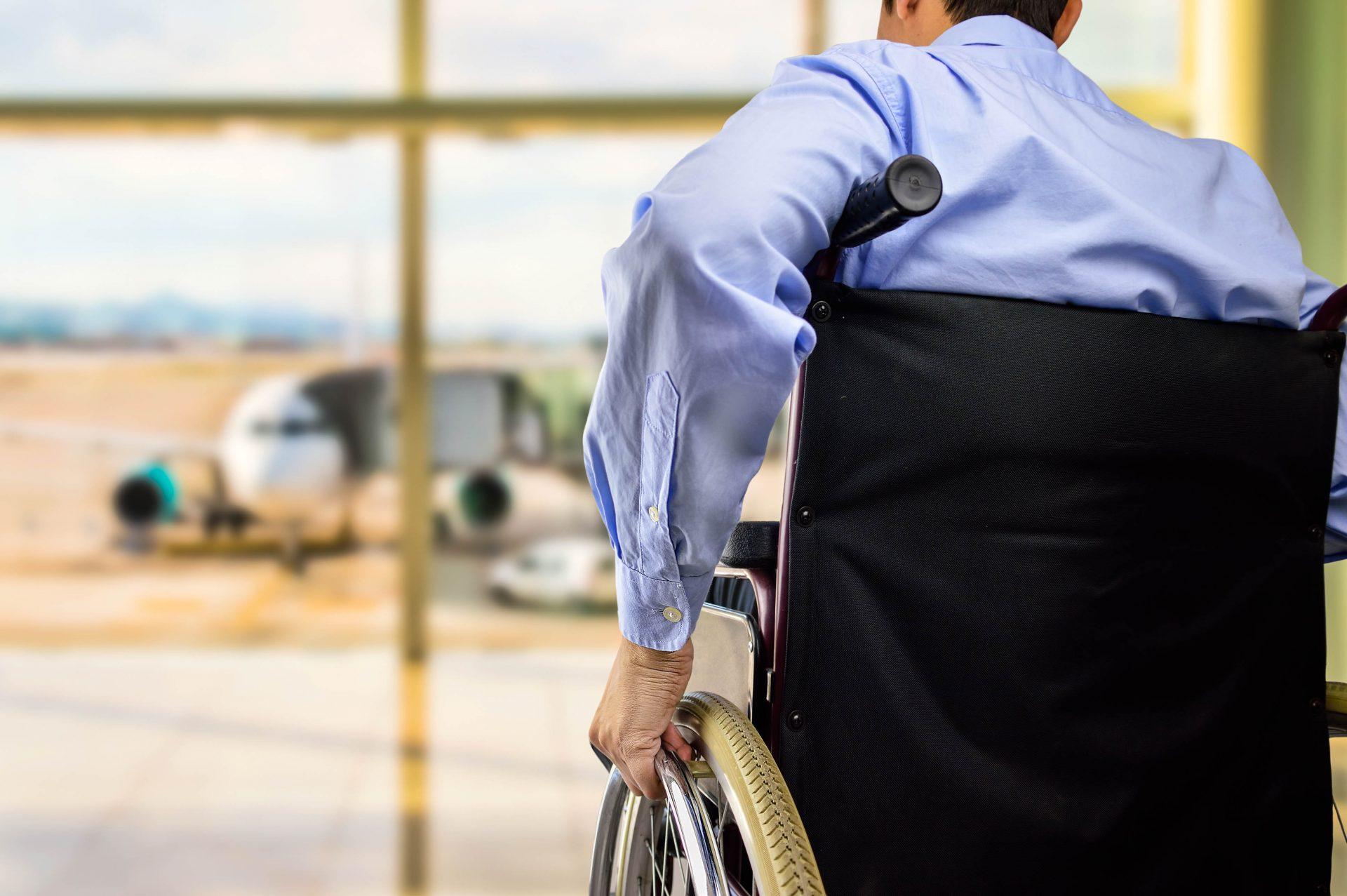 A man waits in a wheelchair for his flight