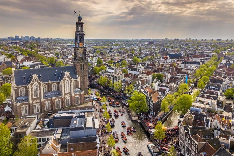 View of the Westerkerk in Amsterdam, surrounded by canals and houses, one of the 10 most beautiful cities in Europe.