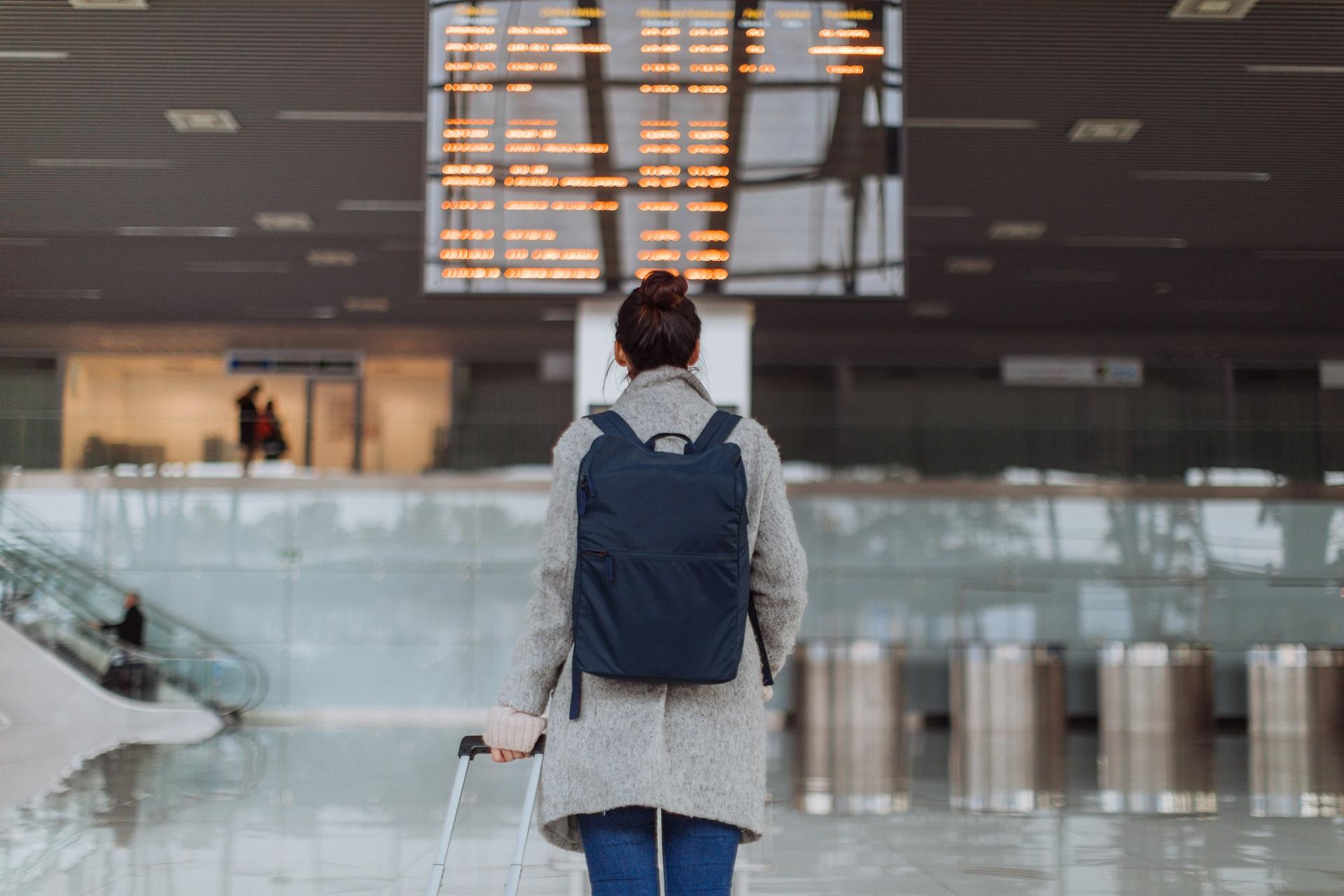A woman travels with carry-on luggage