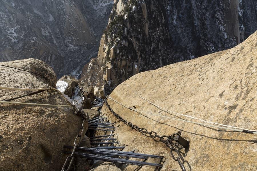 A metal ladder carved into the stone is the path of the dangerous hiking trail Hua Shan in China.