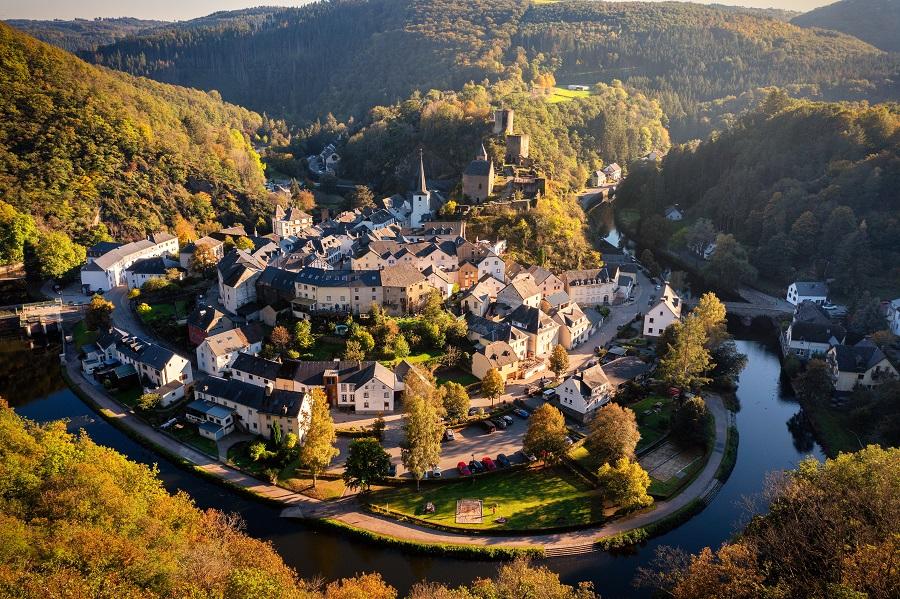 Aerial view of Esch-sur-Sure, a medieval town in Luxembourg, dominated by Wiltz Castle in Diekirch. Surrounded by forests of the Upper Sure Nature Park, winding the winding Sauer River, near Upper Sauer Lake.