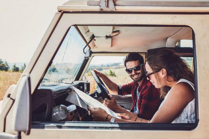 Couple in a van looking at a world map