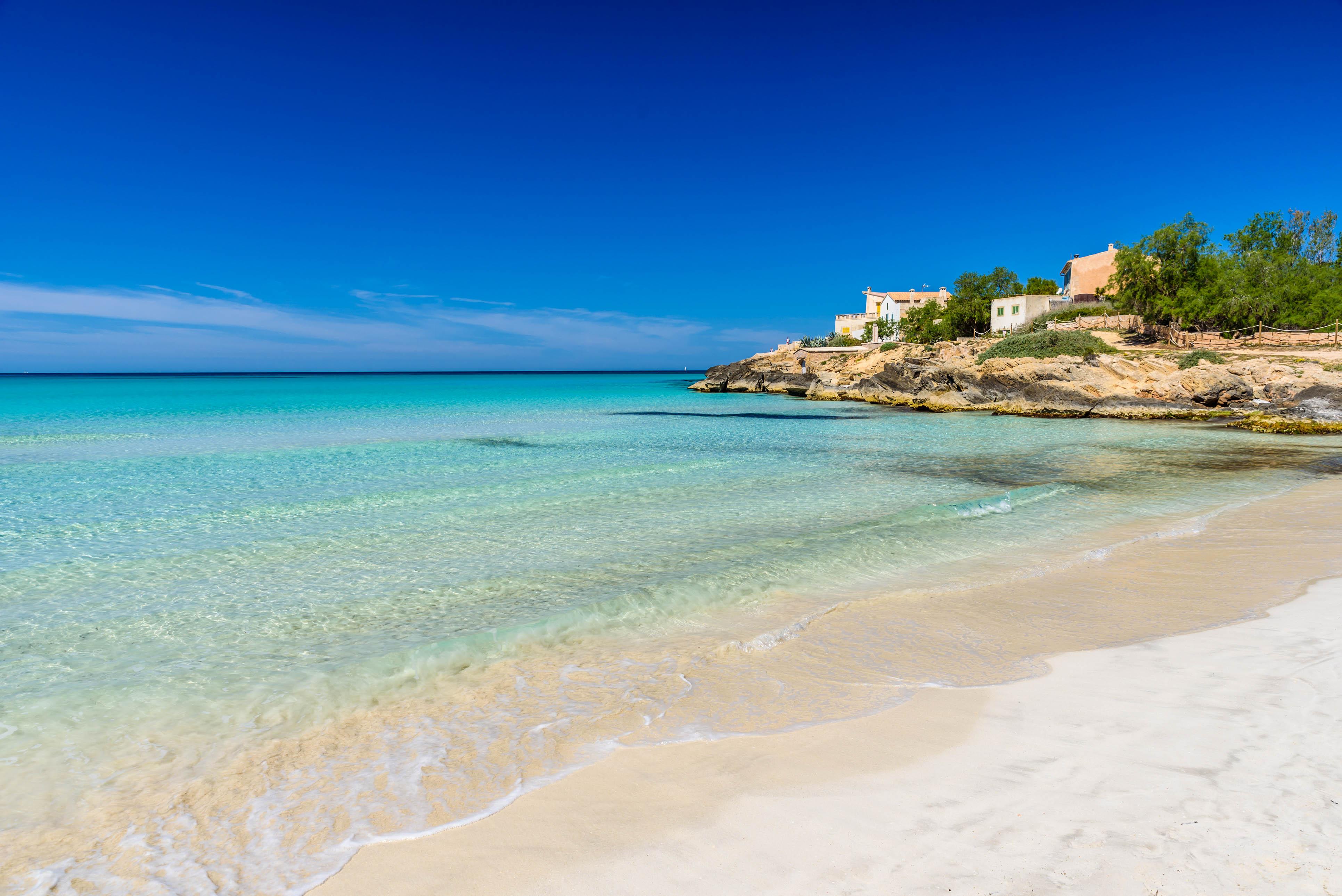 The sea at Es Trenc beach shimmers in beautiful shades of turquoise.