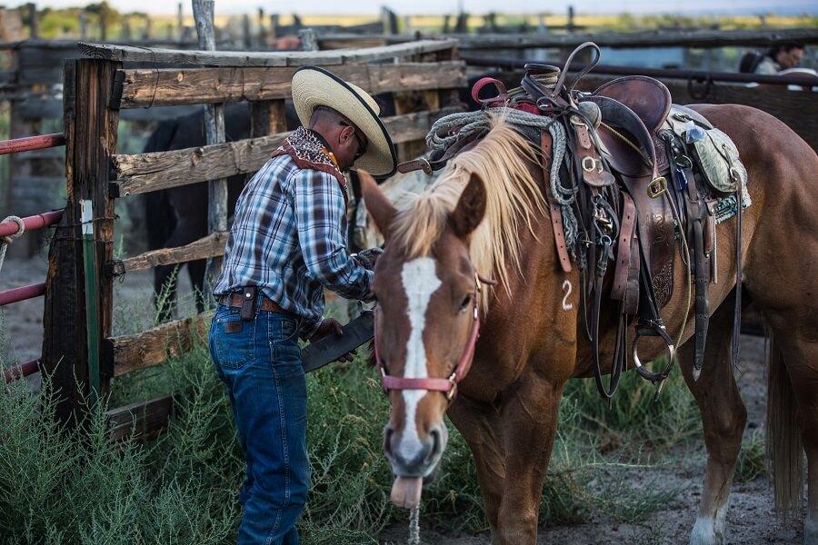 Man in the USA saddling his horse
