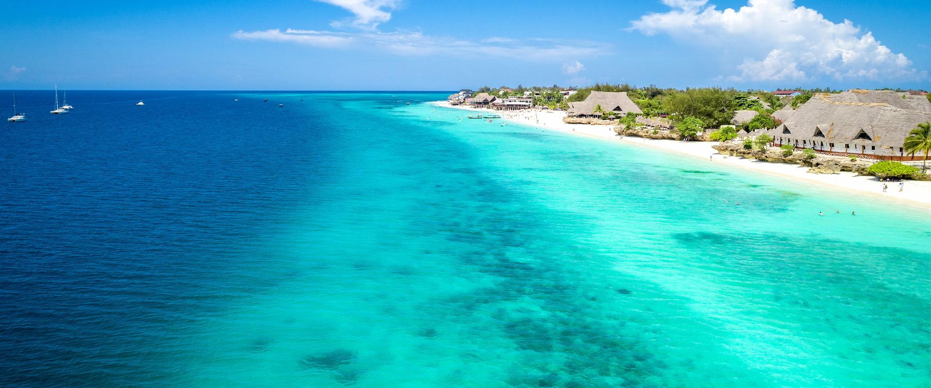 Turquoise water and picturesque beach scenery at Nungwi Beach on Zanzibar. An idyllic beach day during a family vacation on the spice island.