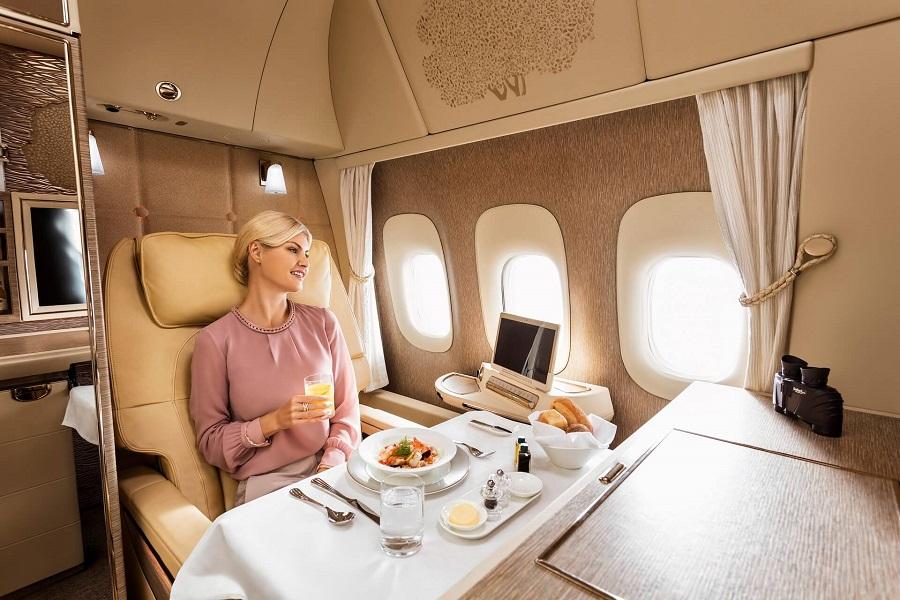 Mulher jantando na Suíte da Primeira Classe da Emirates