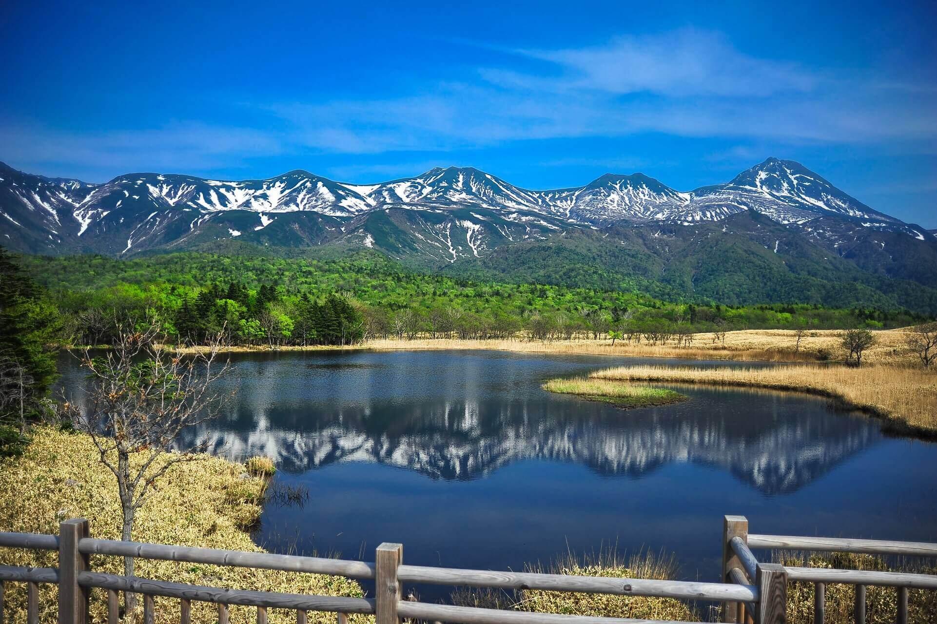 Snow-covered mountains reflected in a lake in Shiretoko National Park, Hokkaido, Japan