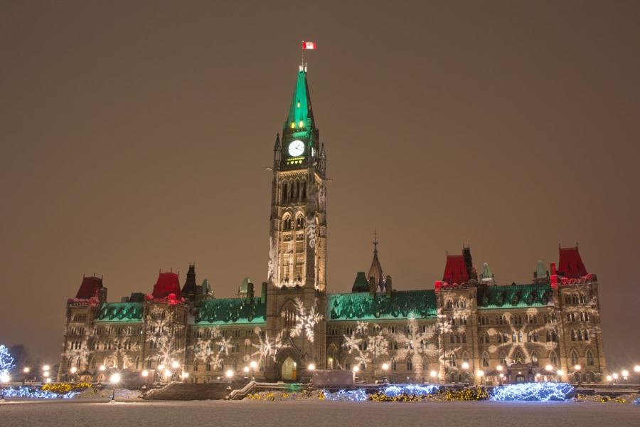 The Canadian Parliament decorated for the winter season at night.