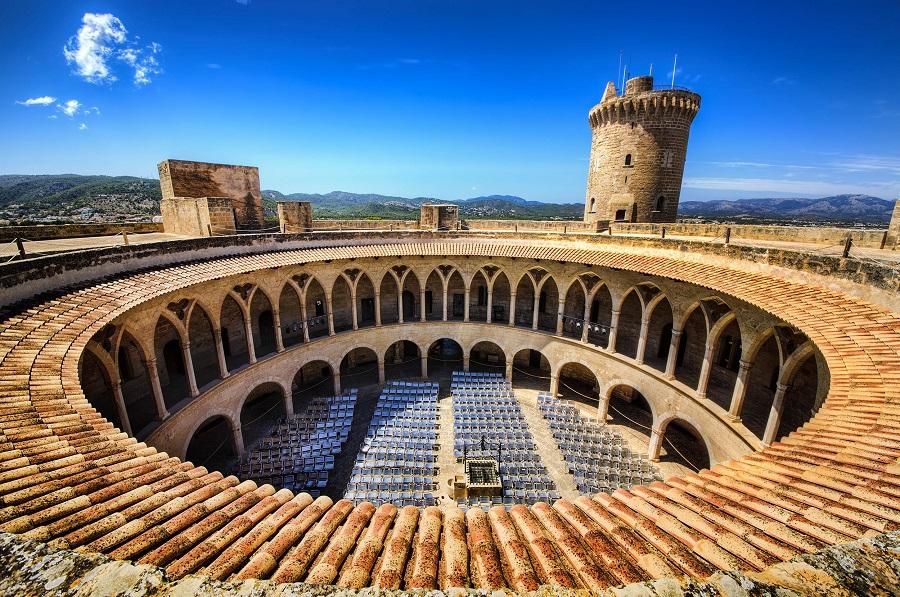 Castillo de Bellver in Palma de Mallorca with its round courtyard and tall tower in the background is a fascinating sight for a family vacation in Mallorca.