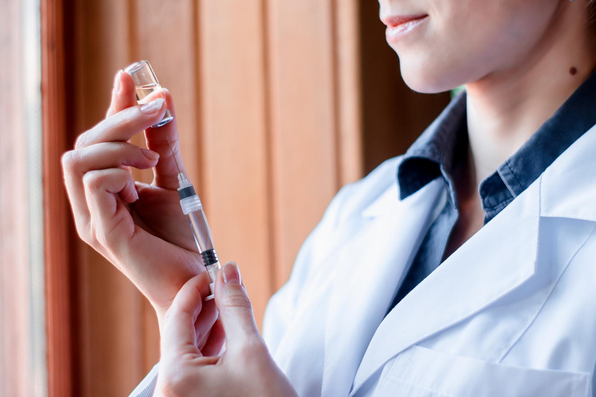 A doctor drawing up a syringe