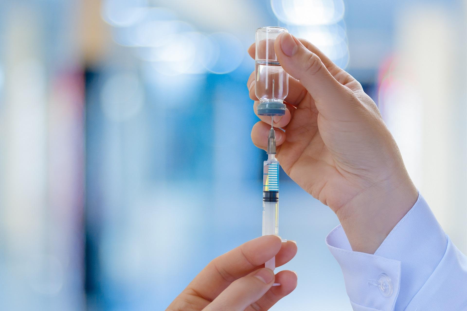 A doctor filling a syringe to administer a travel vaccine