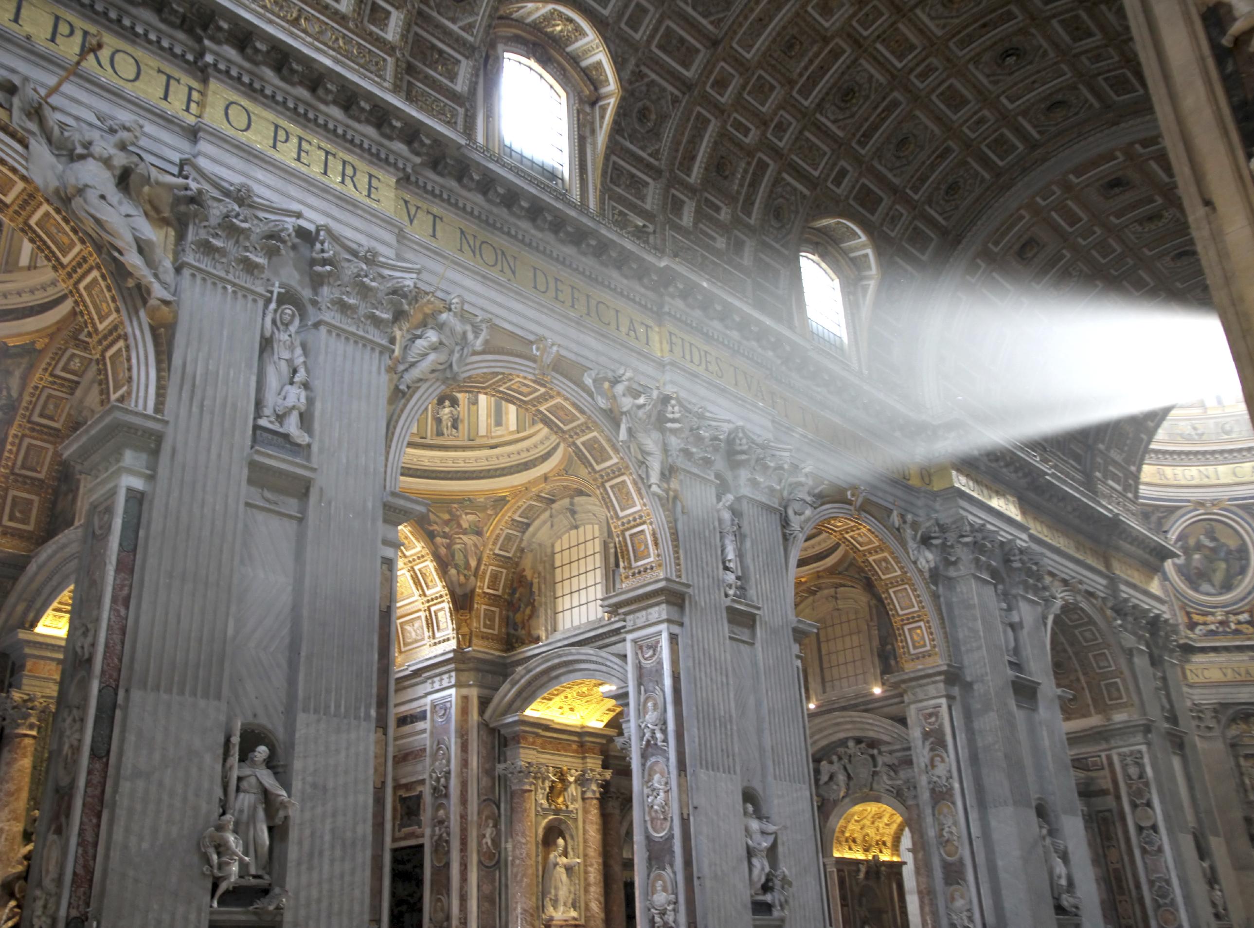 Interior view of St. Peter's Basilica in the Vatican with majestic columns and intricate decorations. Sunbeams fall through windows, illuminating details and creating a peaceful atmosphere.