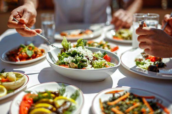 Couple having lunch with fresh salads and appetizers