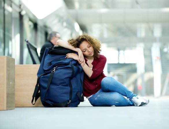 Woman sleeping with luggage at the airport