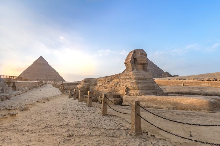 The Sphinx of Giza, a figure with a lion's body and a human head, with the pyramids in the background.