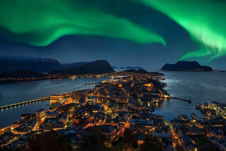 Northern lights, green Aurora borealis over Alesund, Norway.