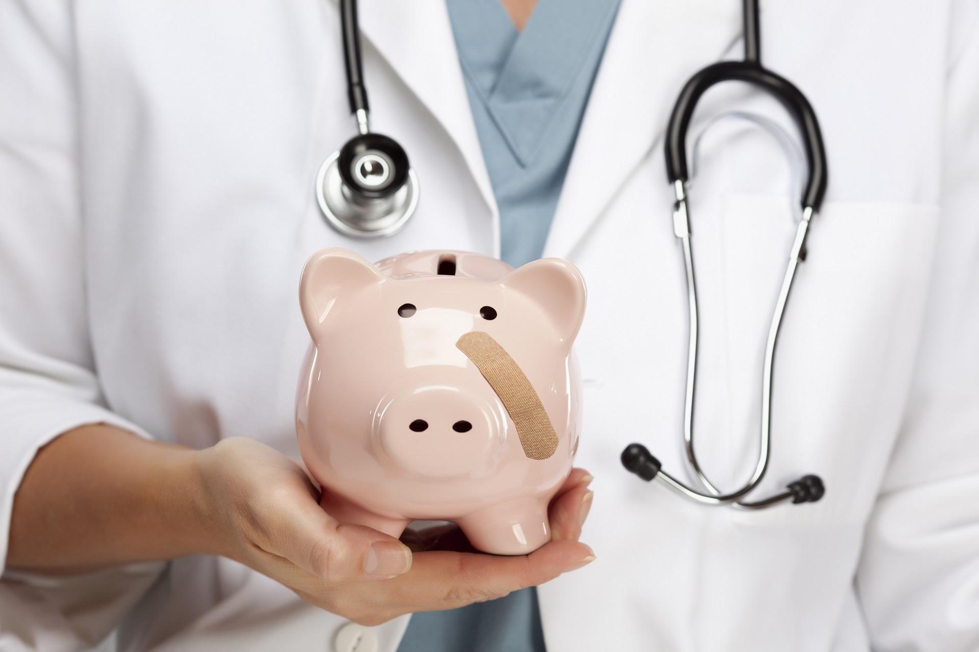 A broken piggy bank held by a doctor